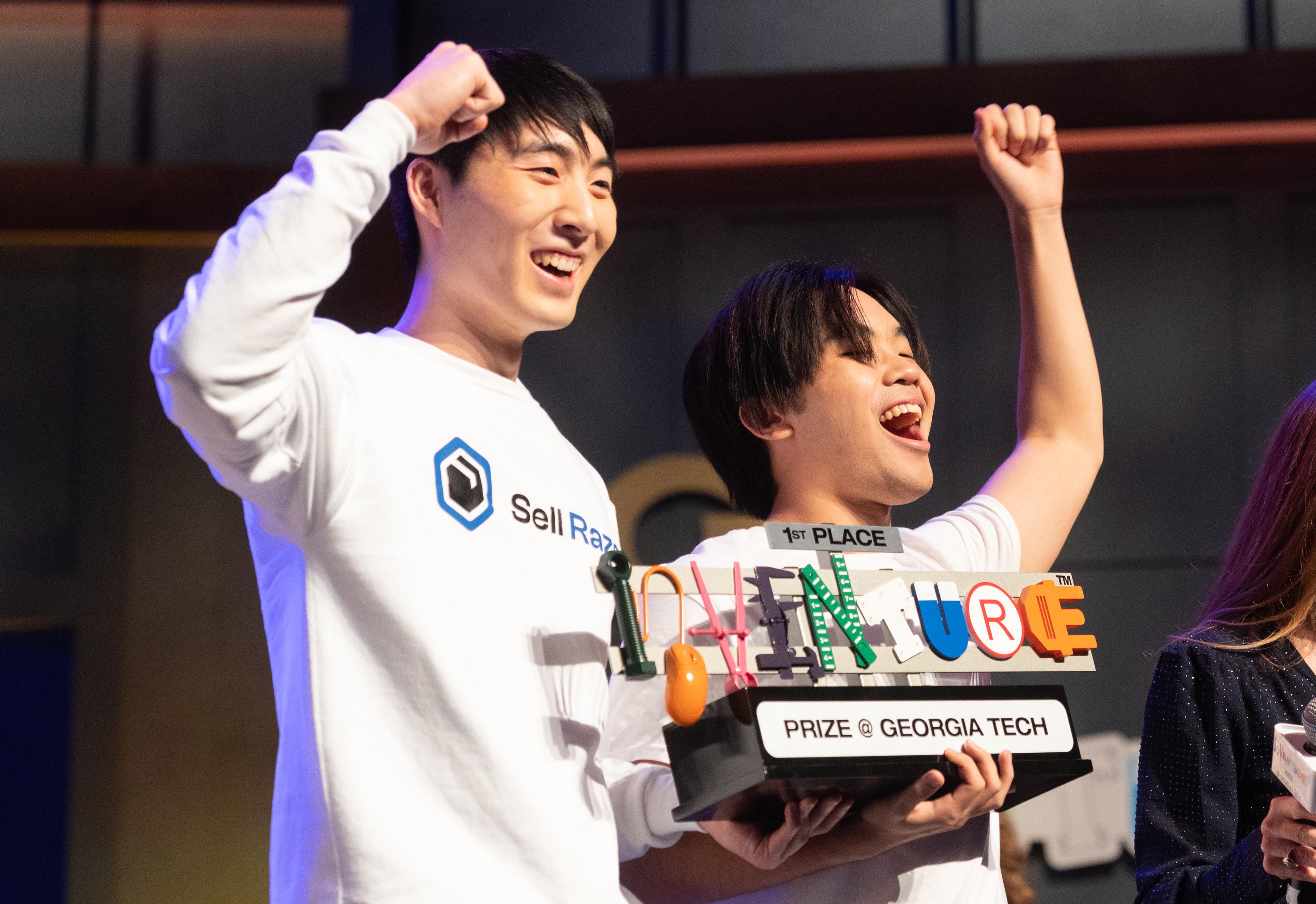 two students celebrate with the inventure prize trophy